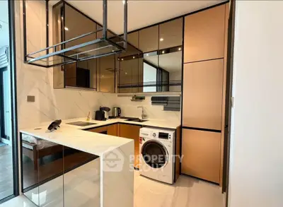 Modern kitchen with sleek cabinetry and built-in washing machine in a stylish apartment.