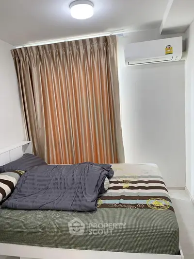 Cozy bedroom with modern air conditioning and elegant curtains, perfect for a comfortable living experience.
