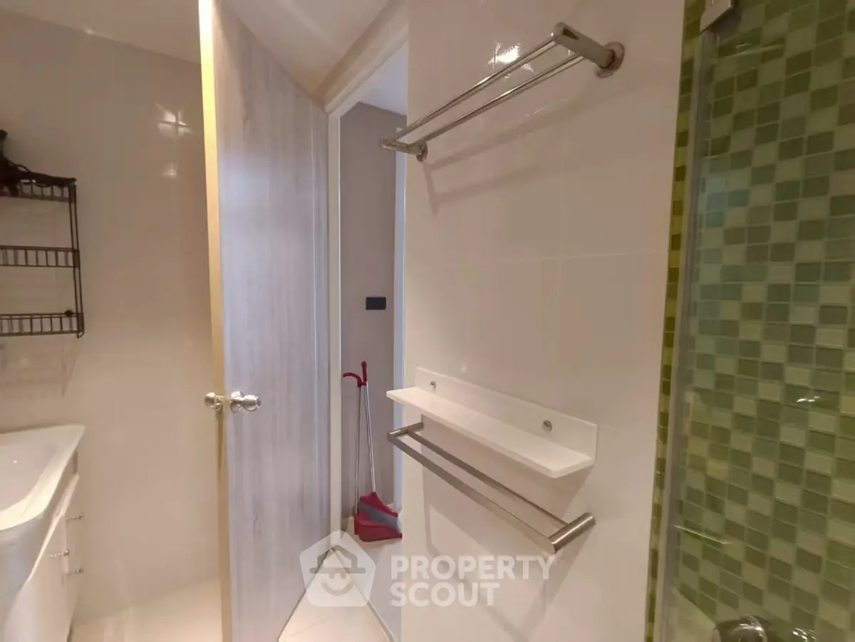 Modern bathroom with sleek fixtures and green tile accents