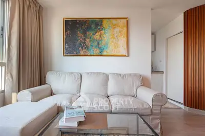Modern living room with elegant beige sofa and abstract art, perfect for stylish urban living.