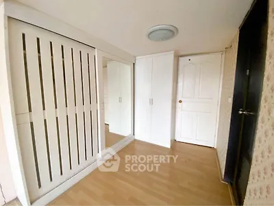Spacious entryway with wooden flooring and ample storage solutions.