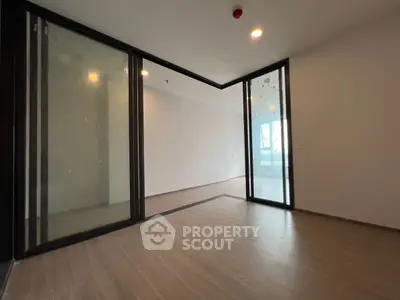 Spacious modern living room with sliding glass doors and wood flooring