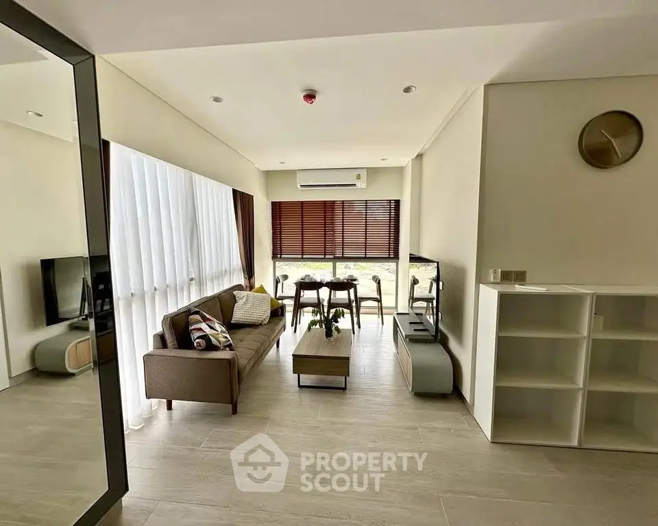 Modern living room with stylish decor and large windows offering natural light.