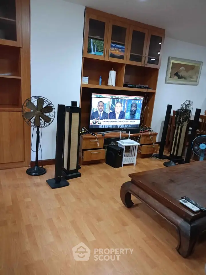 Spacious living room with wooden flooring and modern entertainment setup