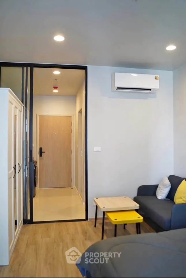Modern living room with sleek furniture and air conditioning in a stylish apartment.