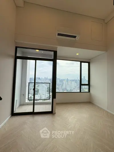 Spacious high-rise apartment with stunning city view and balcony access.