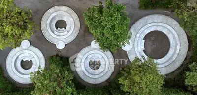 Stunning aerial view of modern circular outdoor seating area surrounded by lush greenery.