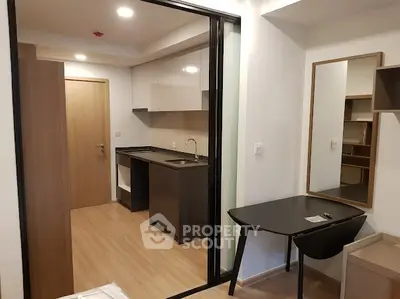 Modern studio apartment with sleek kitchen and workspace, ideal for urban living.