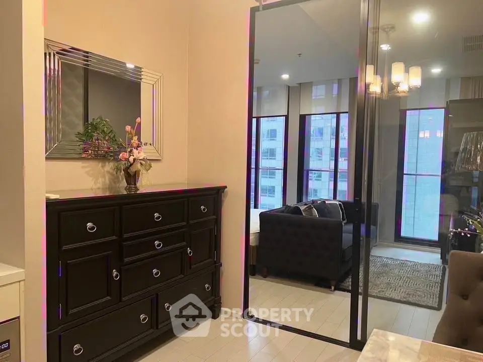 Stylish modern living room with elegant furniture and large mirror reflecting natural light.