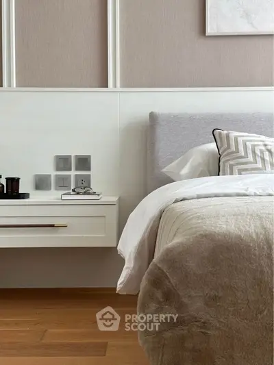 Luxurious bedroom with plush bedding and modern side table, showcasing elegant interior design.