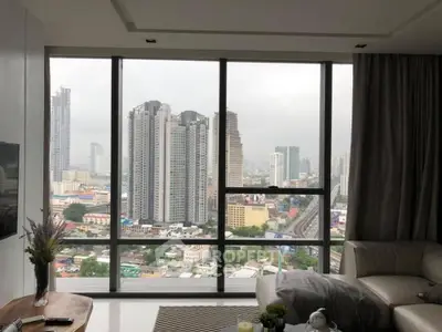 Spacious living room with panoramic city view from large windows.