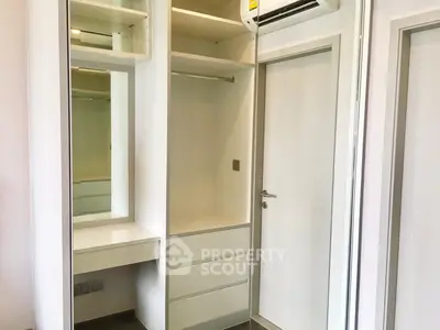 Spacious walk-in closet with built-in shelves and drawers in modern apartment.