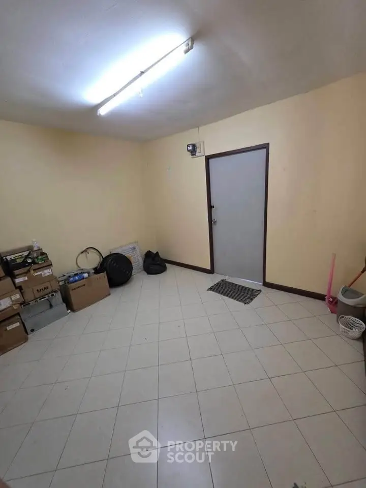 Spacious storage room with tiled floor and ample lighting, ideal for organizing and storing belongings.