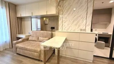 Modern living room with elegant sofa and open kitchen layout in stylish apartment.