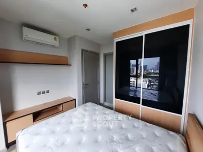 Modern bedroom with city view, featuring built-in wardrobe and air conditioning.