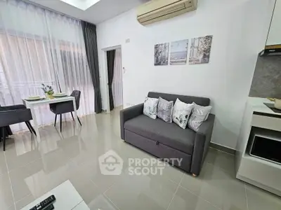 Modern living room with sleek furniture and dining area, featuring elegant decor and natural light.