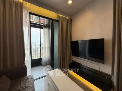 Modern living room with large TV and balcony view in high-rise apartment