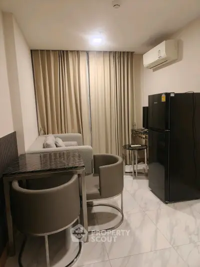 Modern living room with sleek furniture and appliances in a cozy apartment setting.