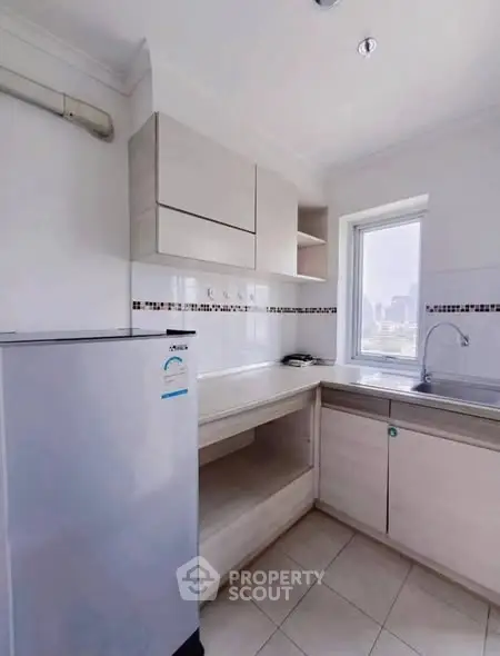 Modern kitchen with sleek cabinetry and city view window