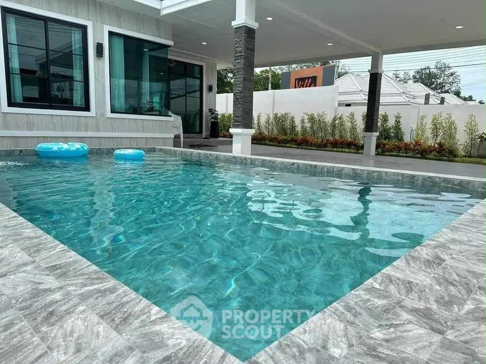 Luxurious modern home with sparkling private pool and elegant patio area, perfect for relaxation and entertainment.