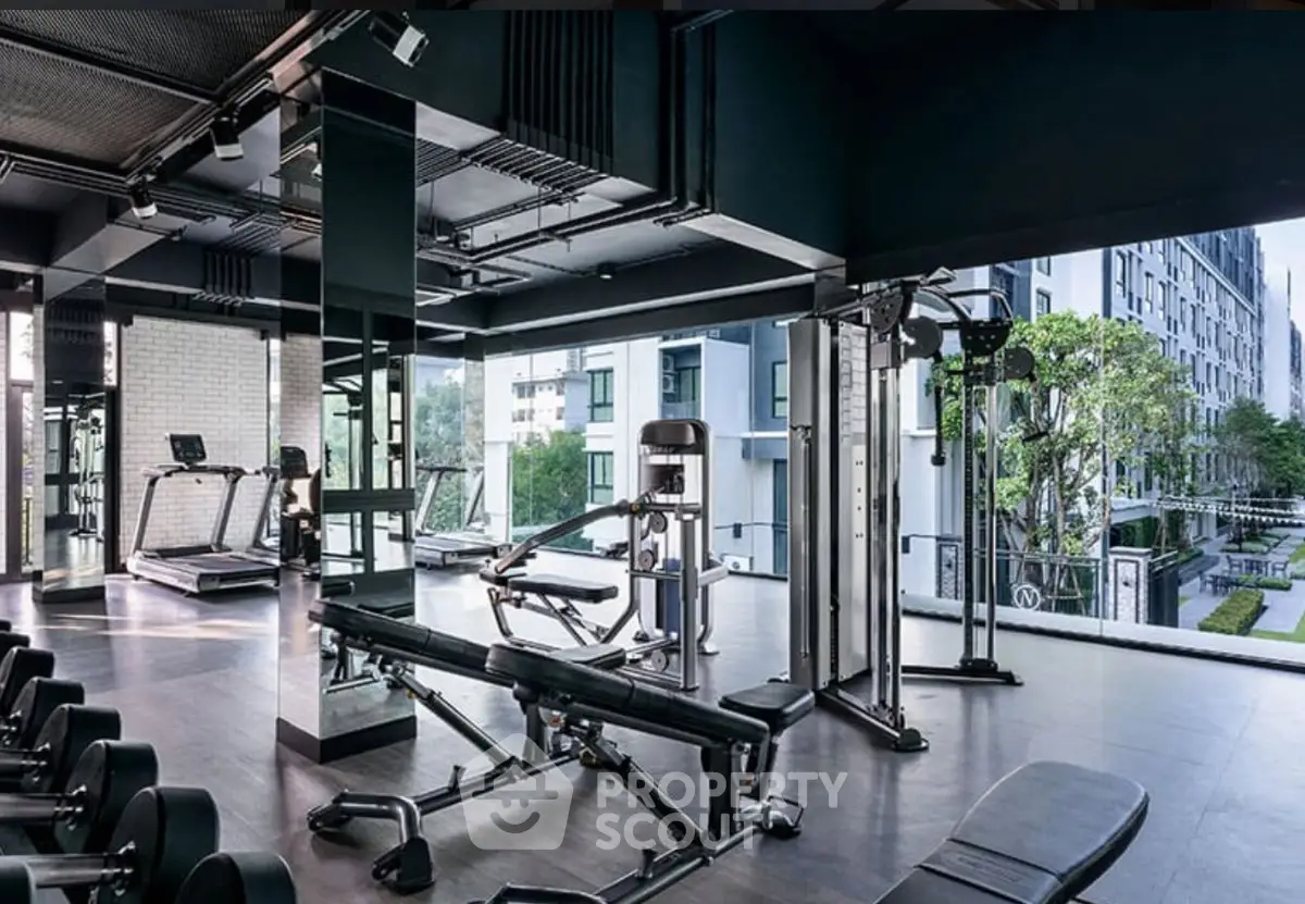 Modern gym with state-of-the-art equipment and scenic outdoor view in luxury apartment complex.