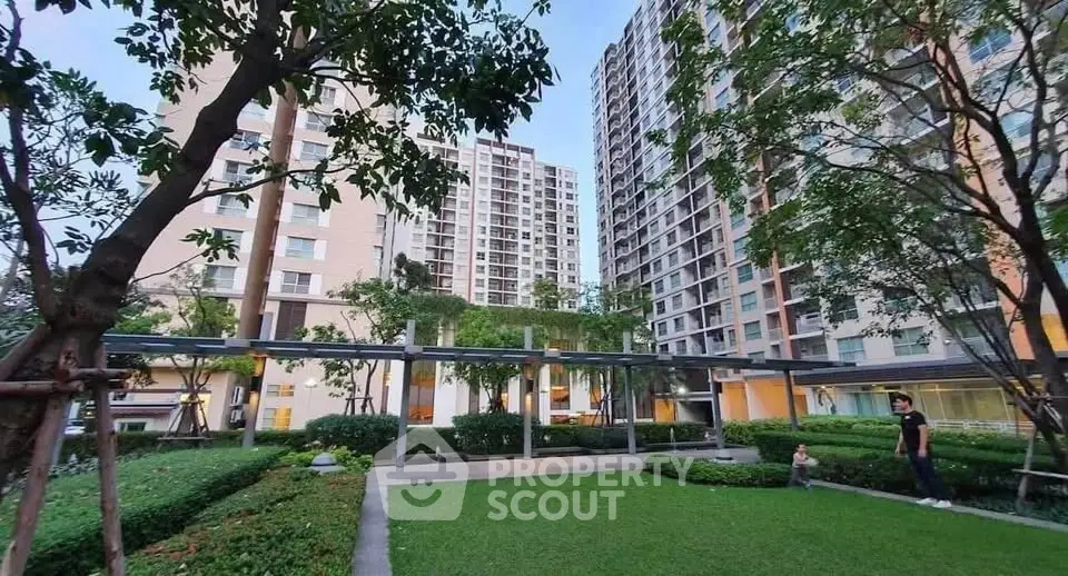 Modern apartment complex with lush garden and tall buildings