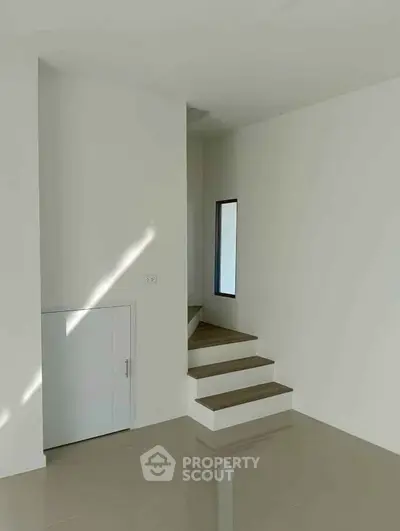 Minimalist interior with sleek staircase and glossy floor, perfect for modern living.