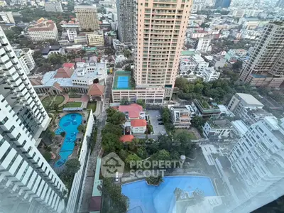 Stunning cityscape view from high-rise building with pools and lush greenery
