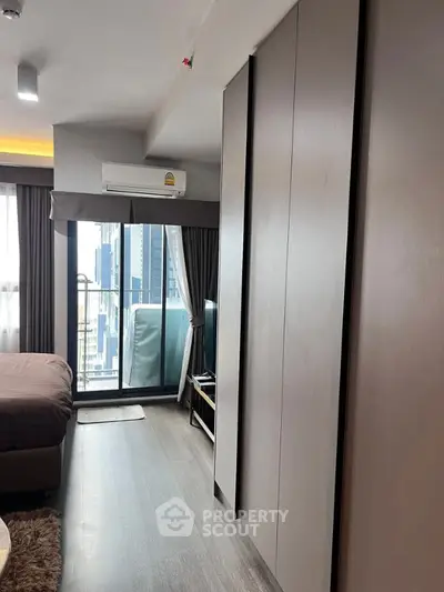 Modern bedroom with balcony and city view in high-rise apartment