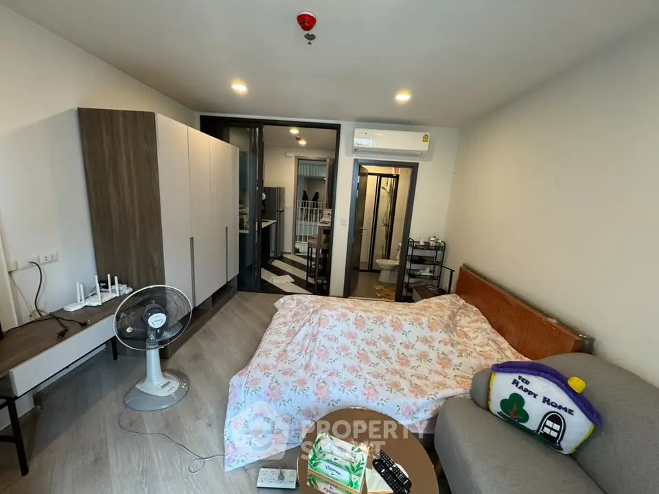 Cozy studio apartment with modern furnishings and open layout, featuring a comfortable bed and stylish decor.