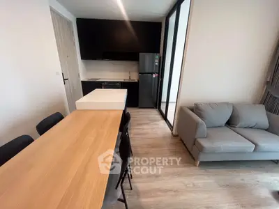 Modern open-plan kitchen and living area with sleek design and cozy furnishings.