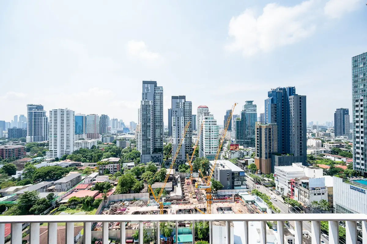 Stunning cityscape view from a high-rise balcony showcasing urban skyline and construction progress.