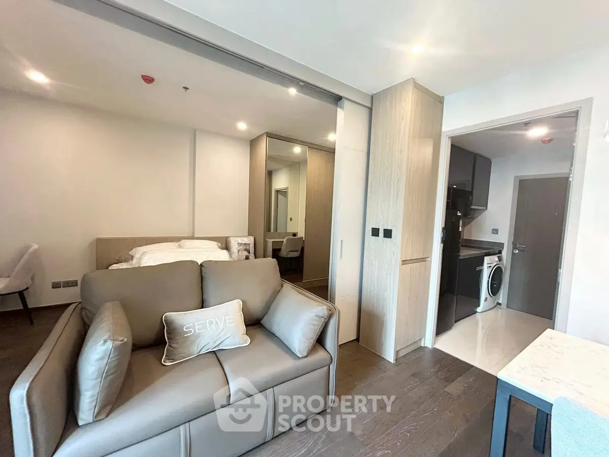 Modern studio apartment with sleek interior design and compact kitchen