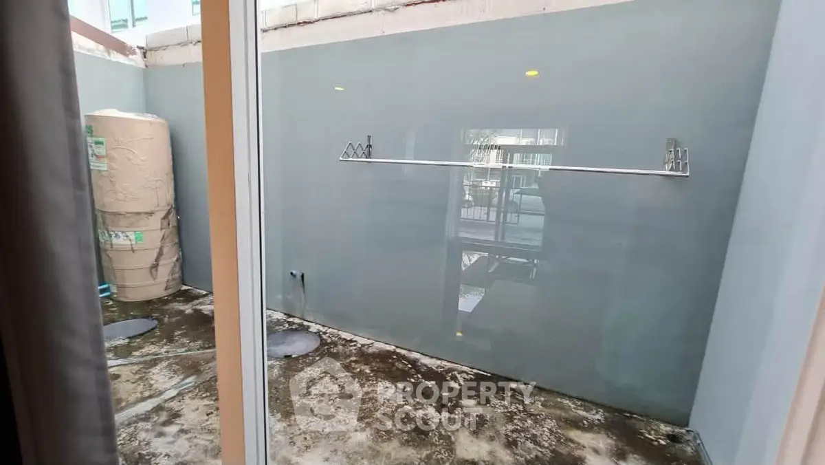 Spacious outdoor area with potential for customization, featuring concrete flooring and high privacy walls.