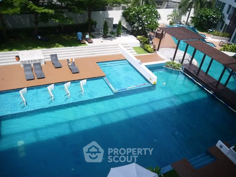Luxurious residential pool with stylish deck and seating area in a serene garden setting.