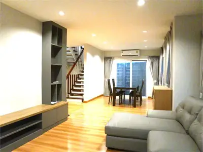 Spacious modern living room with elegant staircase and dining area