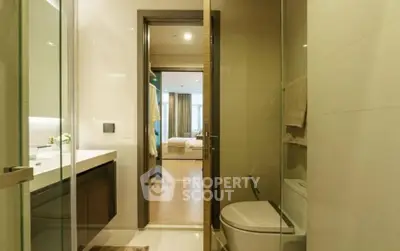Modern bathroom with sleek finishes leads to a cozy bedroom, perfect for urban living with a touch of luxury and comfort.
