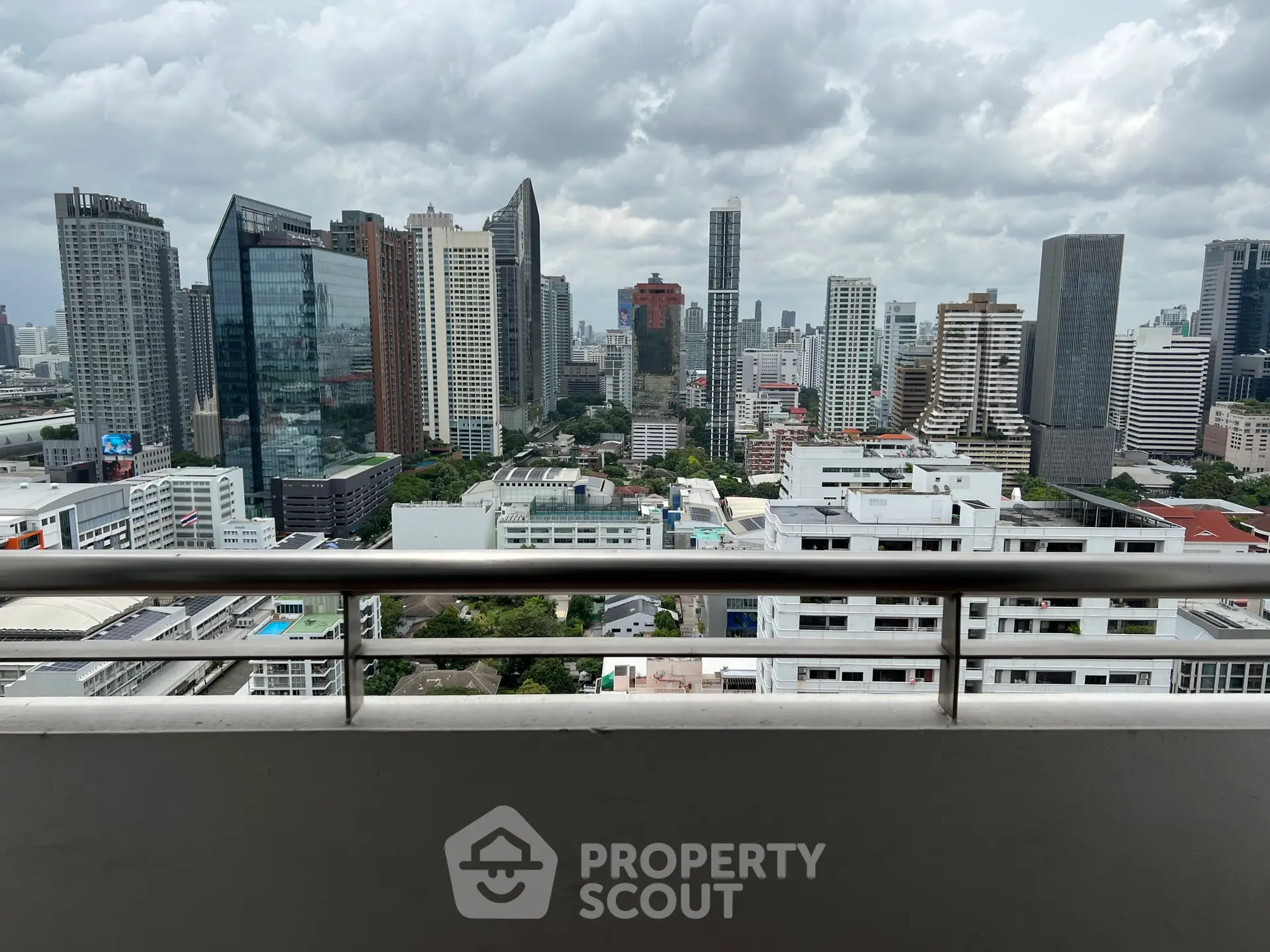 Stunning cityscape view from a high-rise balcony overlooking modern skyscrapers and urban landscape.