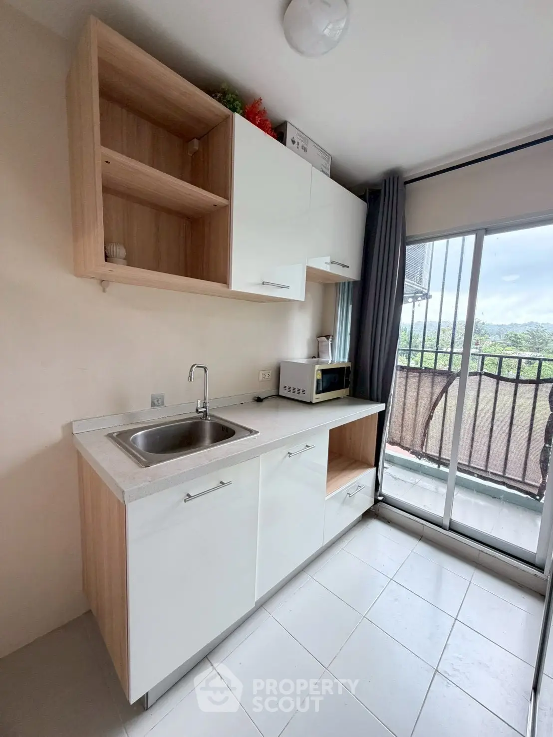 Modern kitchen with sleek cabinets and balcony view, perfect for urban living.