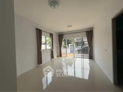 Spacious unfurnished living room with large windows and sliding glass doors leading to a patio.