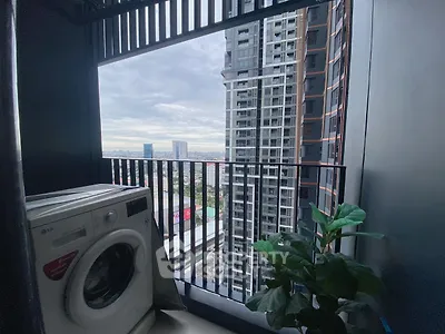 Modern balcony with washing machine and city view in high-rise building