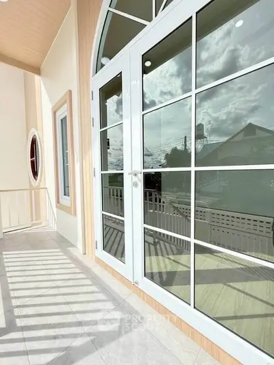 Spacious balcony with elegant glass doors and scenic view