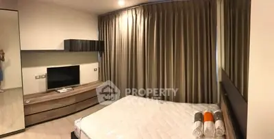 Modern bedroom with sleek furniture and large mirror, featuring a cozy ambiance and stylish decor.
