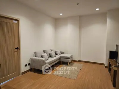 Cozy living room with modern gray sofa and wooden flooring