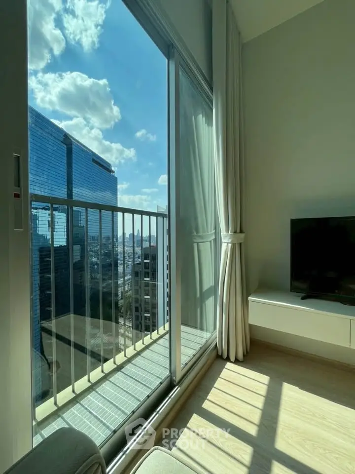 Bright modern living room with large windows and city view, perfect for urban living.