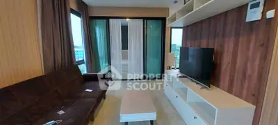 Modern living room with sleek furniture and large windows offering natural light.