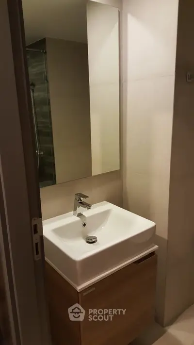 Modern bathroom with sleek sink and large mirror in minimalist design.