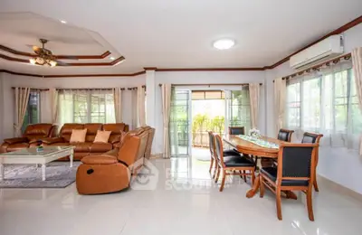 Spacious living room with elegant furniture and large windows offering natural light.