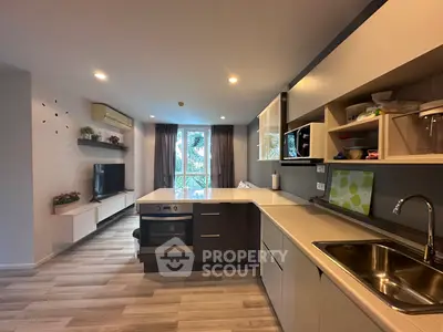 Modern open-layout kitchen with sleek cabinets and built-in oven in a stylish apartment.