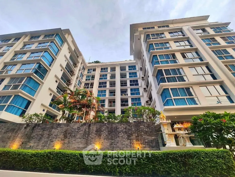 Modern apartment building with lush landscaping and contemporary architecture.